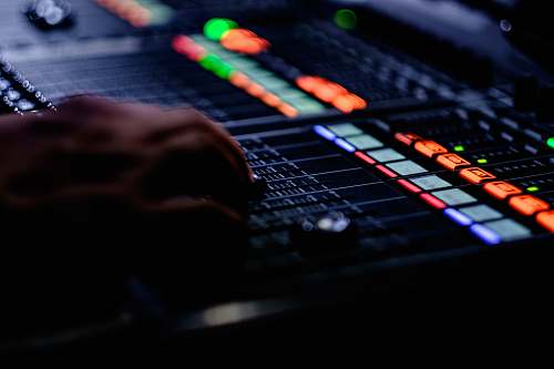 computer hardware person's hand on black audio mixer computer keyboard
